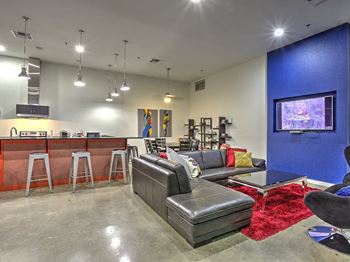 A living room with a blue accent wall and a kitchen
